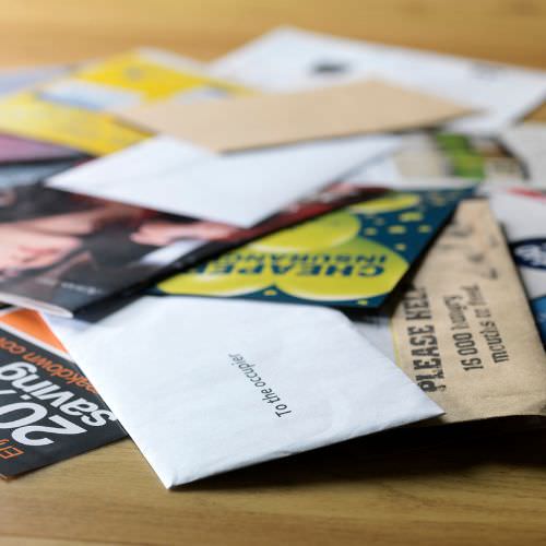 A stack of direct mail laying on a table