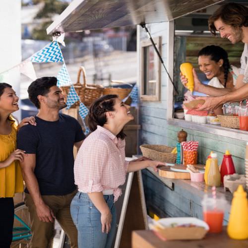 A group of young people ordering food at a food truck.